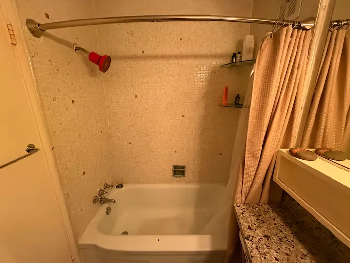 The tiled tub and shower in the shared bathroom