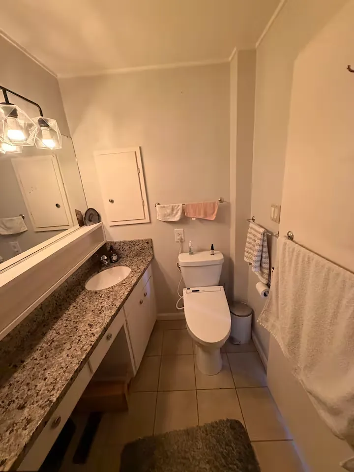 The shared bathroom with a granite vanity and a bidet toilet seat
