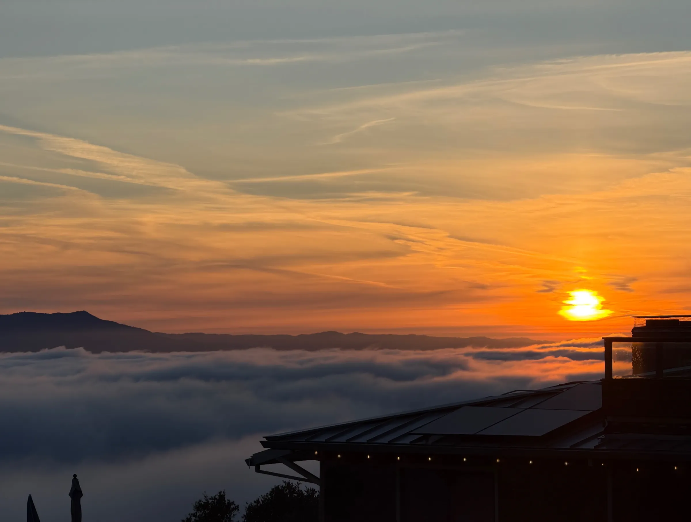 The sun setting over a sea of fog, with Mount Tamalpais on the horizon, seen from the Berkeley Hills